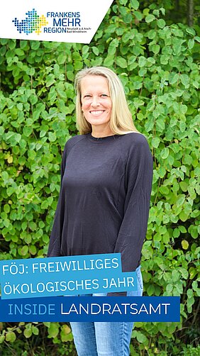 Person vor grünem Blätterhintergrund, lächelnd und leger gekleidet