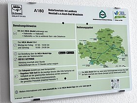 Informationsschild zum Bedarfsverkehr „NEA Mobil“ im Landkreis Neustadt a.d. Aisch–Bad Windsheim. Es enthält Angaben zur Nutzung, Betriebszeiten (Montag bis Freitag von 07:00 bis 18:00 Uhr), Buchungsmöglichkeiten per App oder Telefon sowie eine Karte des Bediengebiets. Logos von VGN, dem Landkreis und dem On-Demand-System sind ebenfalls abgebildet.