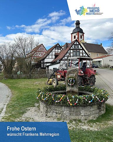 Ostern in Frankens Mehrregion Osterbrunnen vor einem Kirchturm und Fachwerkhäusern